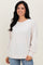 woman wearing a soft beige long sleeve top with raglan sleeves and elastic cuffs, smiling against a neutral background