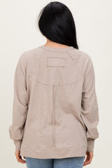 woman wearing a taupe long sleeve sweatshirt with a relaxed fit and back seam detail, shown from the back