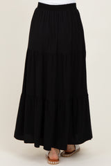woman wearing a black tiered maxi skirt with an elastic waistband and flowy hemline