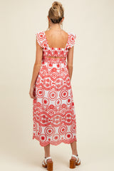 woman wearing a red and white floral print maternity dress with ruffle sleeves and a smocked back