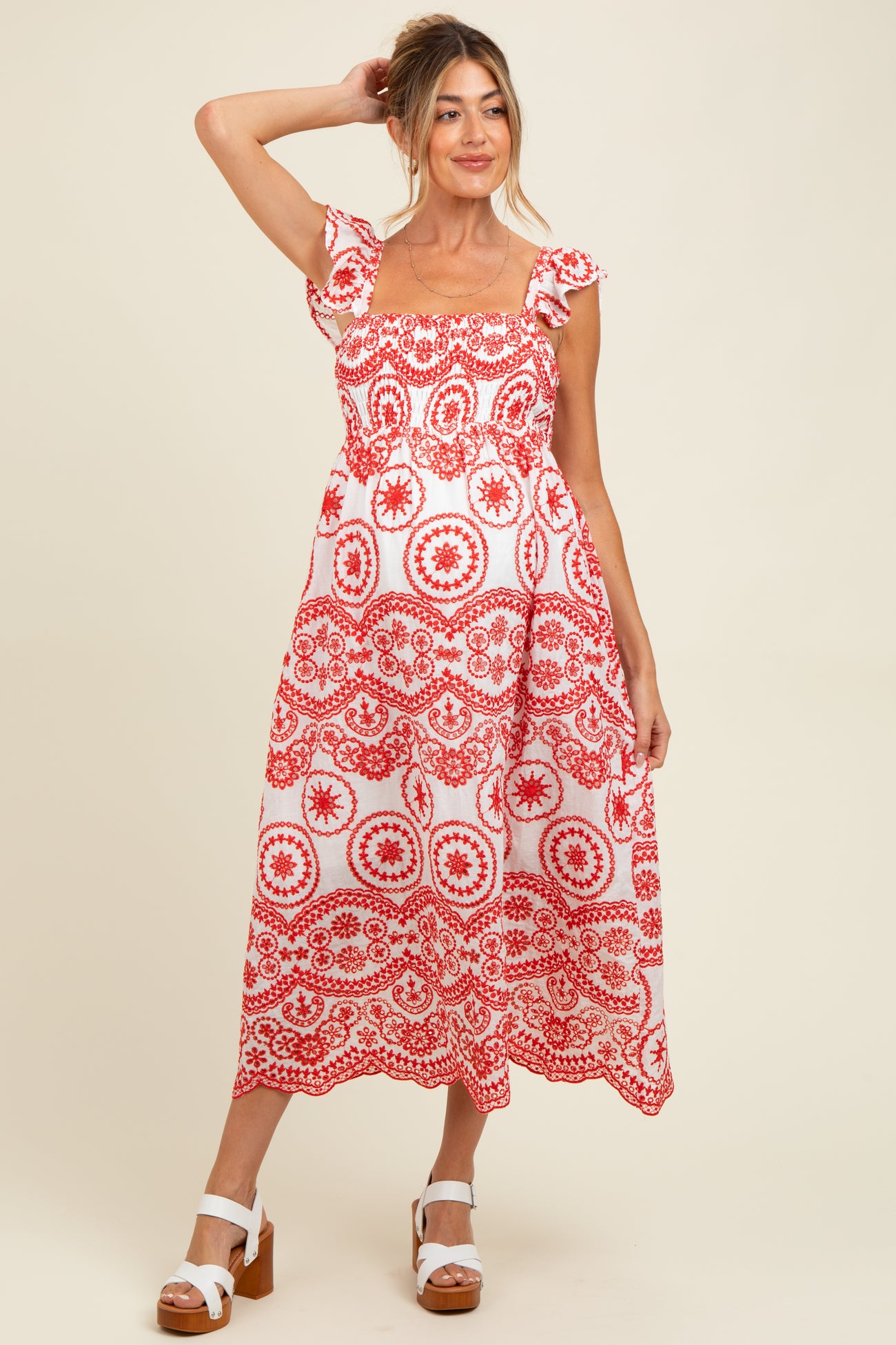 woman wearing a red and white floral print maternity dress with short sleeves and a square neckline