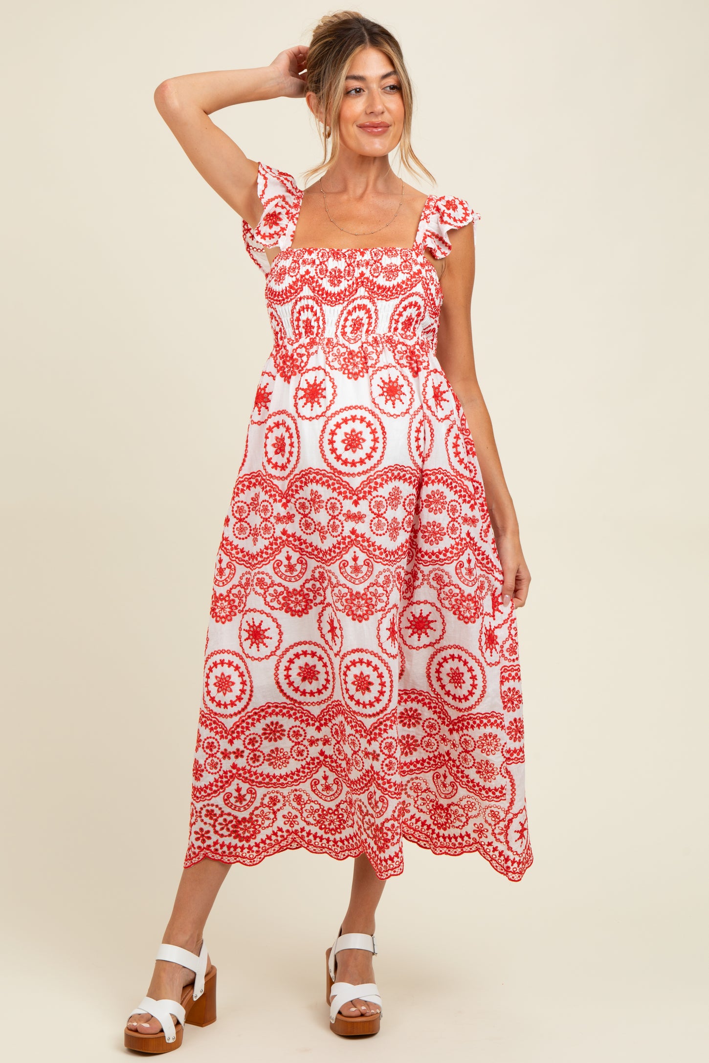woman wearing a red and white floral print maternity dress with short sleeves and a square neckline