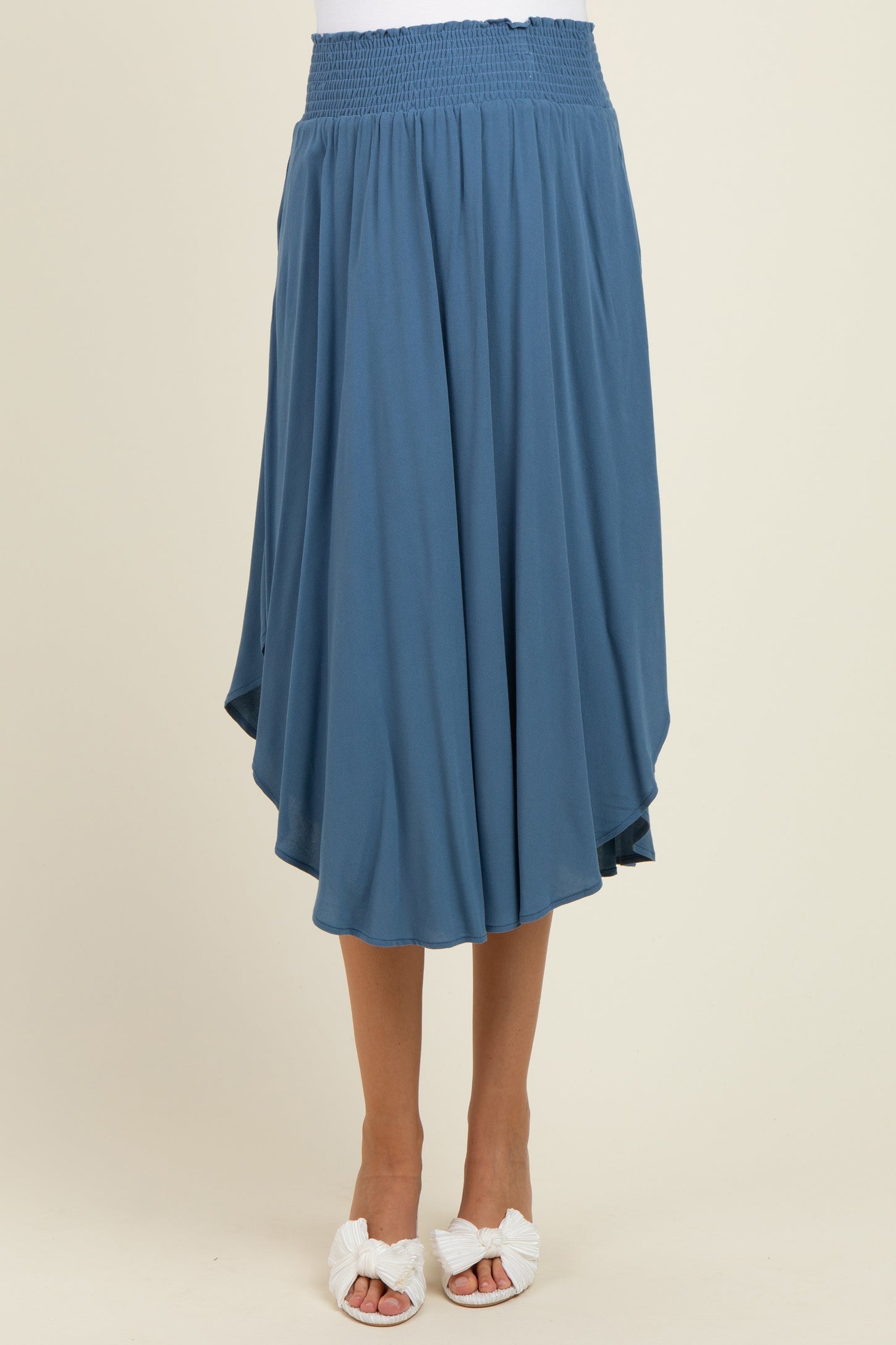 woman wearing a blue maternity skirt with a smocked waist and asymmetrical hemline
