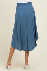 woman wearing a flowy blue maternity skirt with a smocked waist and a slight hi-low hem