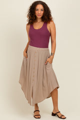 woman wearing a purple ribbed tank top and a beige maternity skirt with buttons and pockets