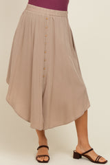 woman wearing a taupe maternity midi skirt with a flowy silhouette and button detailing at the front