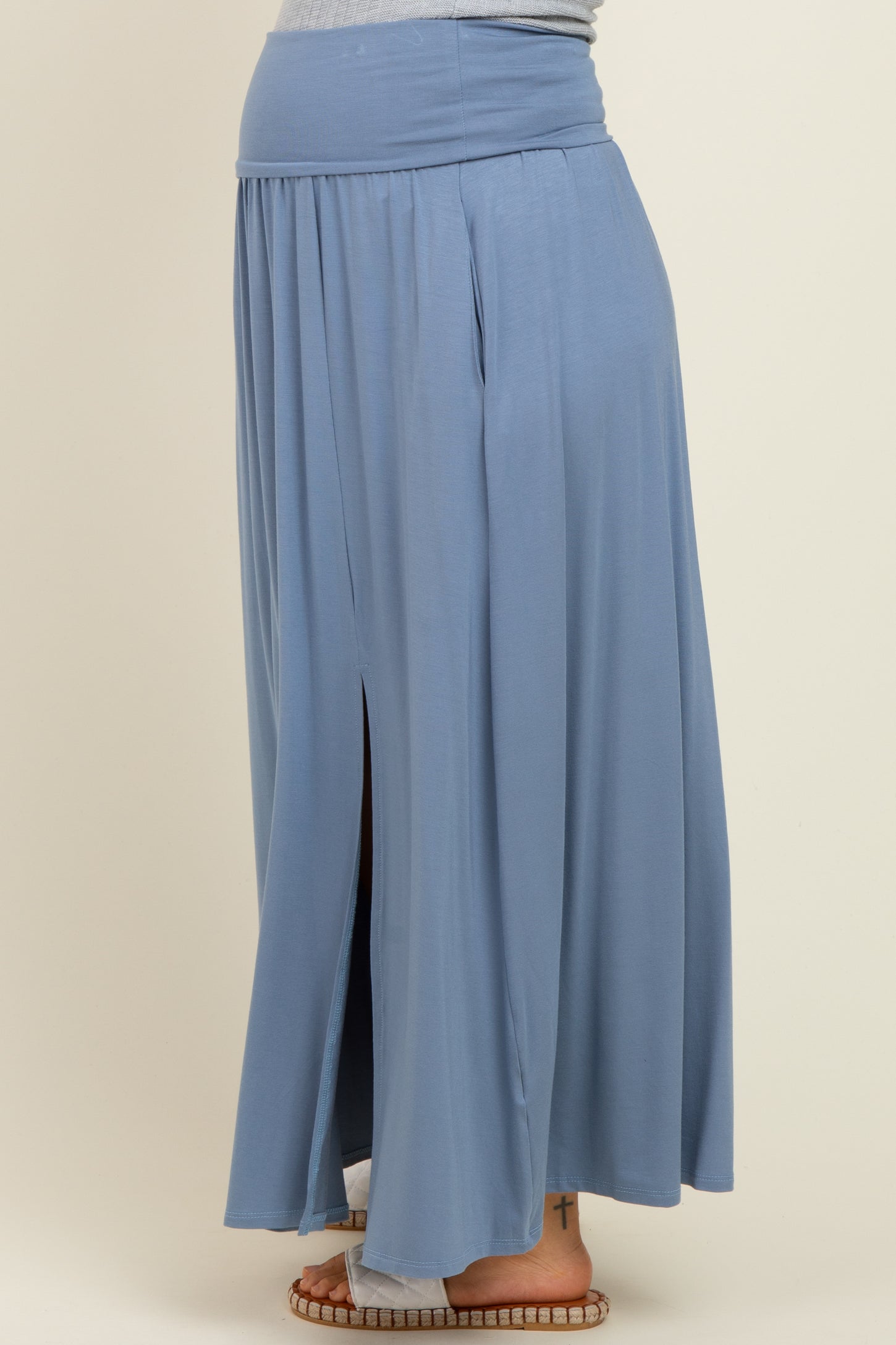 maternity wear long blue maxi skirt with a high slit and comfortable waistband, styled on a model showing a baby bump
