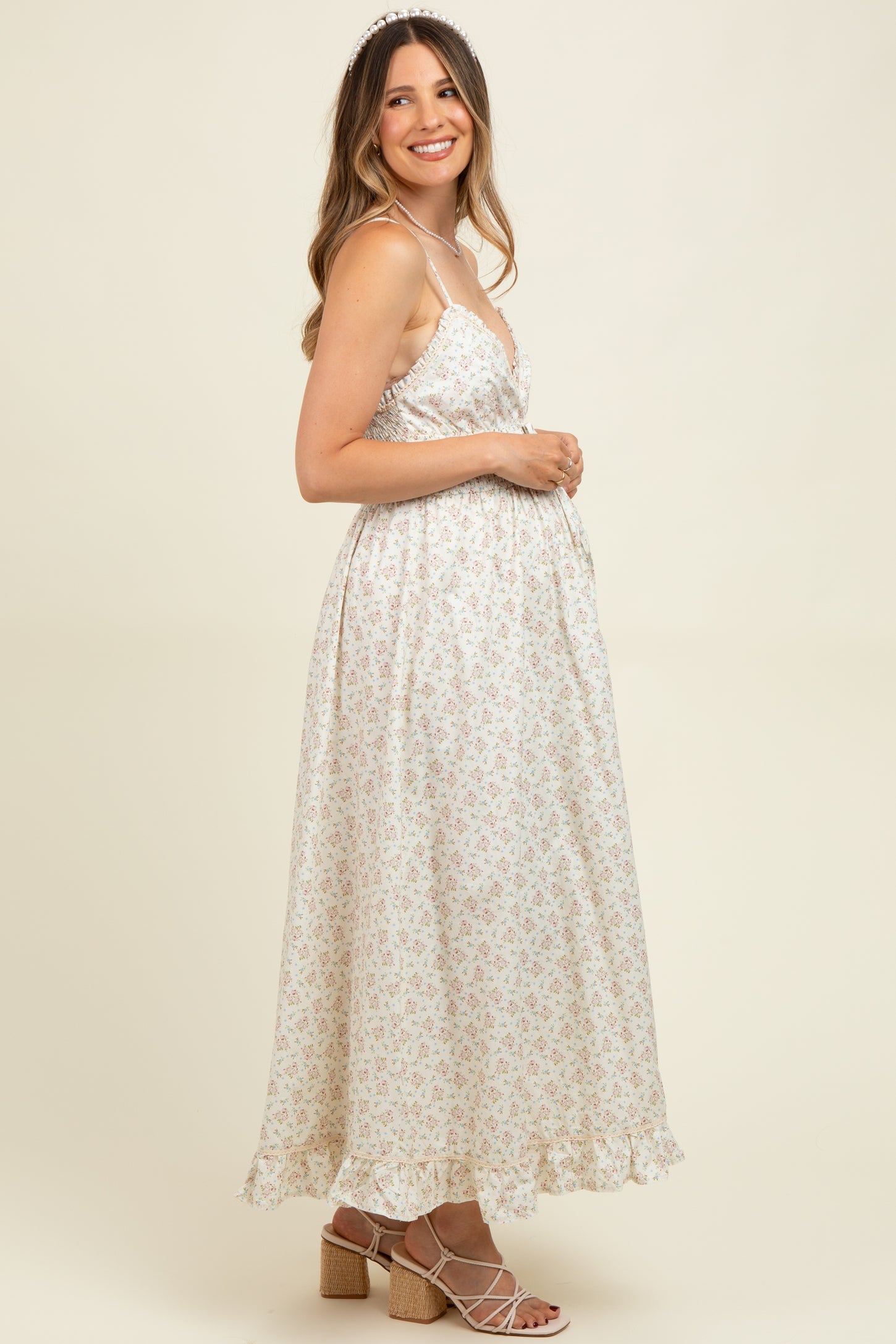 woman wearing a white floral print maternity maxi dress with adjustable straps and a baby bump visible
