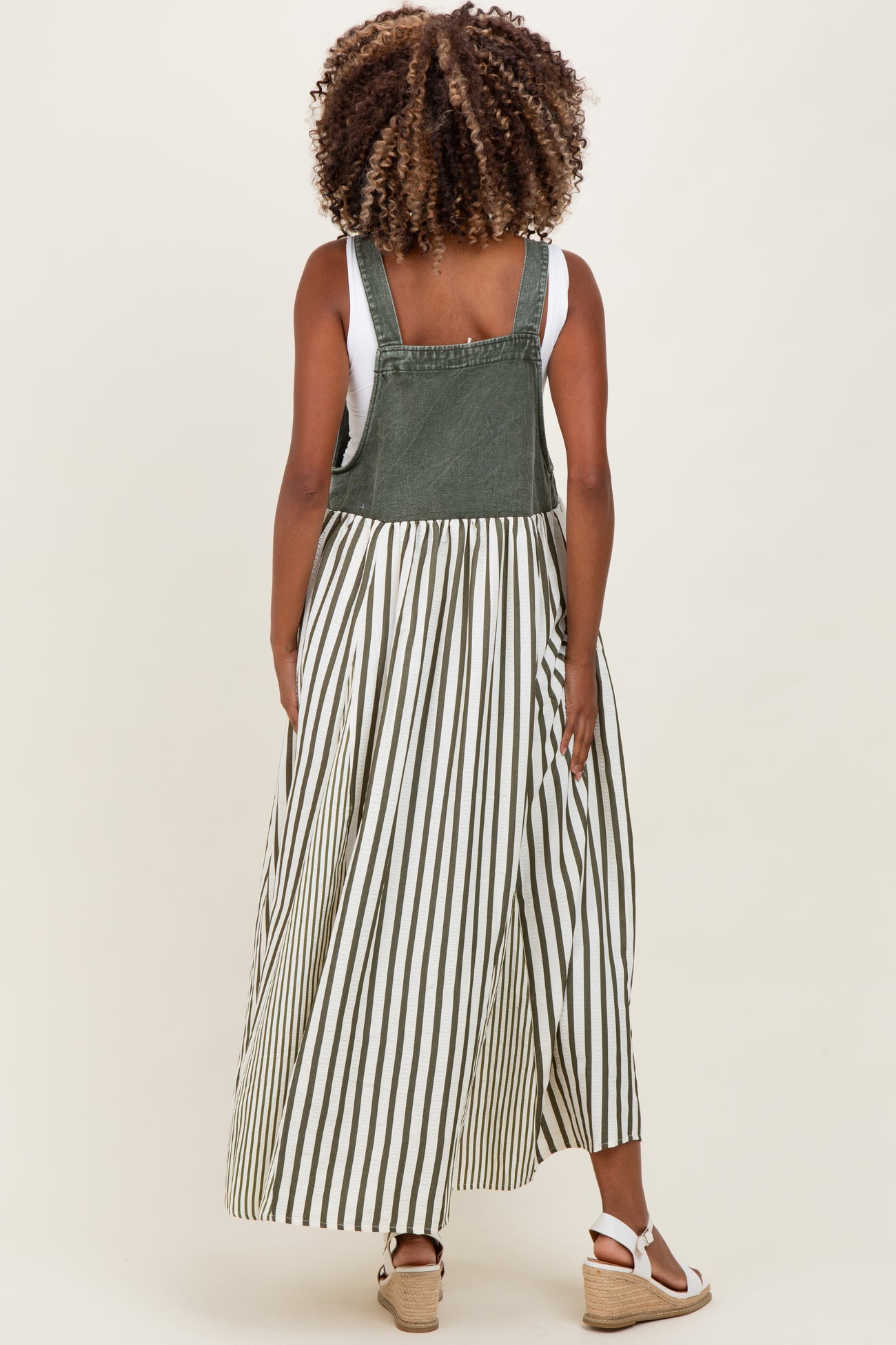 woman wearing a green and white striped maternity dress with a denim top and flowing skirt