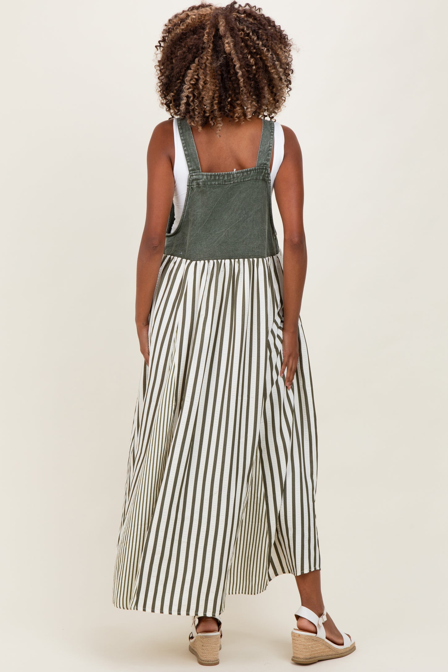 woman wearing a green and white striped maternity dress with a denim top and flowing skirt