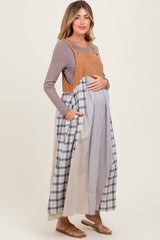 woman wearing a tan corduroy maternity dress with plaid patterns and pockets, showing her baby bump