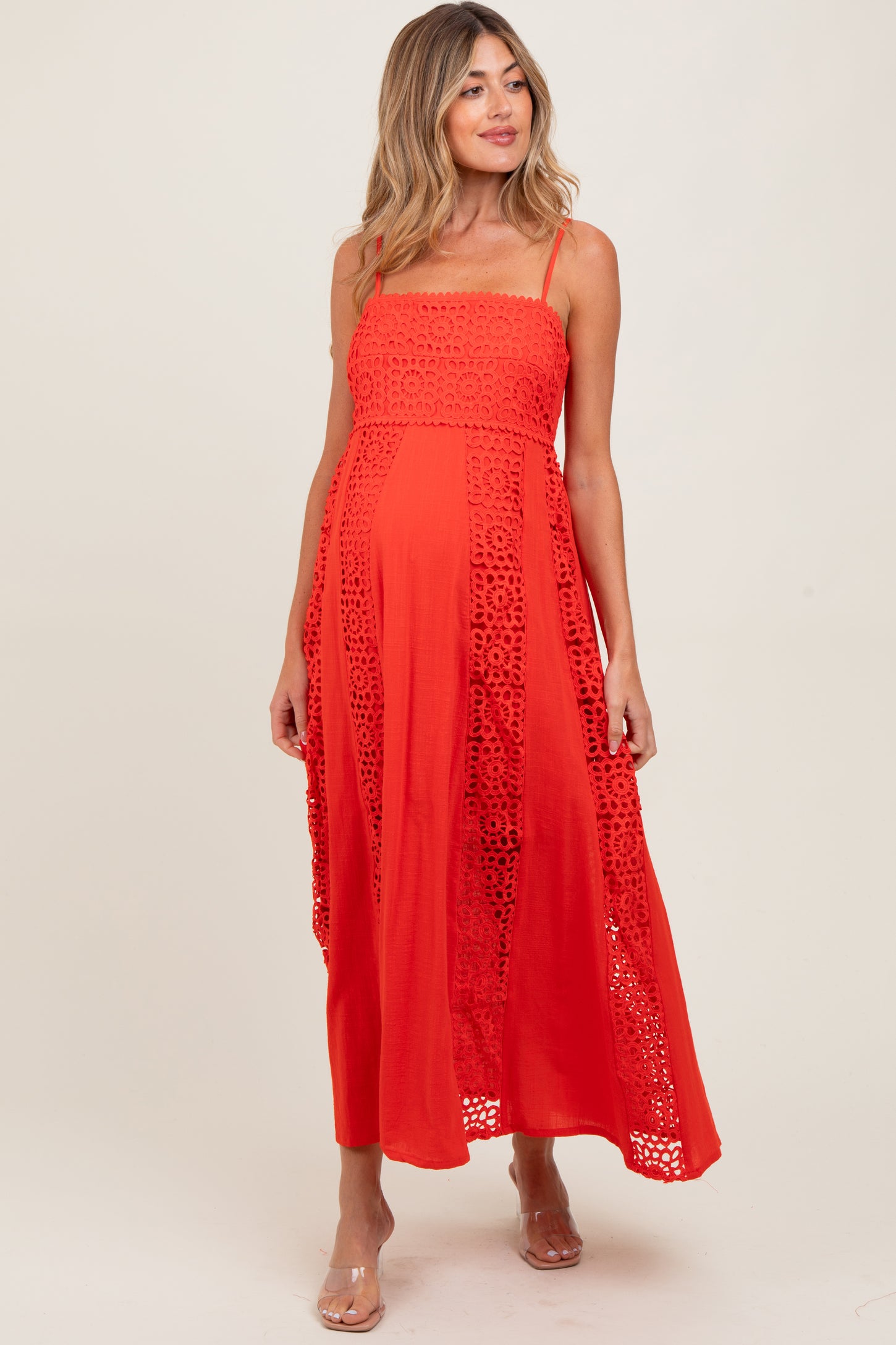 woman wearing a red maternity maxi dress with lace detailing, showcasing a baby bump