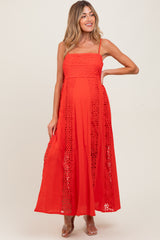 woman wearing a bright red maternity maxi dress with lace details and adjustable straps, showcasing her baby bump