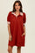 woman wearing a red short sleeve polo dress with striped collar and cuff details