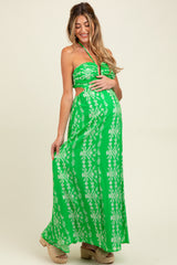woman wearing a green floral print maternity maxi dress with a strapless design and a visible baby bump