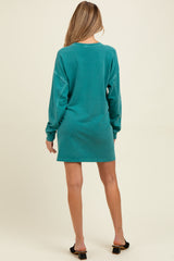 woman wearing a teal long sleeve maternity dress viewed from the back