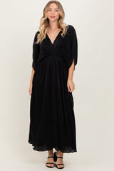 woman wearing a black maxi dress with a deep v-neck and elastic waist, styled with open-toe sandals