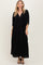 woman wearing a black maxi dress with a deep v-neck and elastic waist, styled with open-toe sandals
