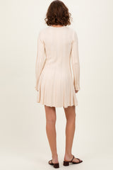 woman wearing a ribbed light beige long sleeve mini dress with a flared skirt and back view shown
