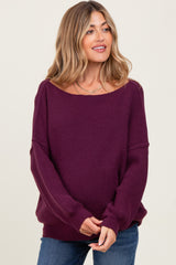 woman wearing a purple oversized maternity sweater with a wide neckline and long sleeves