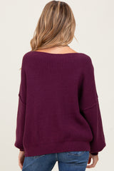 woman wearing a purple oversized off-the-shoulder maternity sweater, shown from the back with loose sleeves