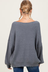 woman wearing a gray oversized ribbed maternity sweater, showing the back view with relaxed fit and long sleeves