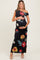 woman wearing a black floral off-shoulder maternity maxi dress and holding her baby bump