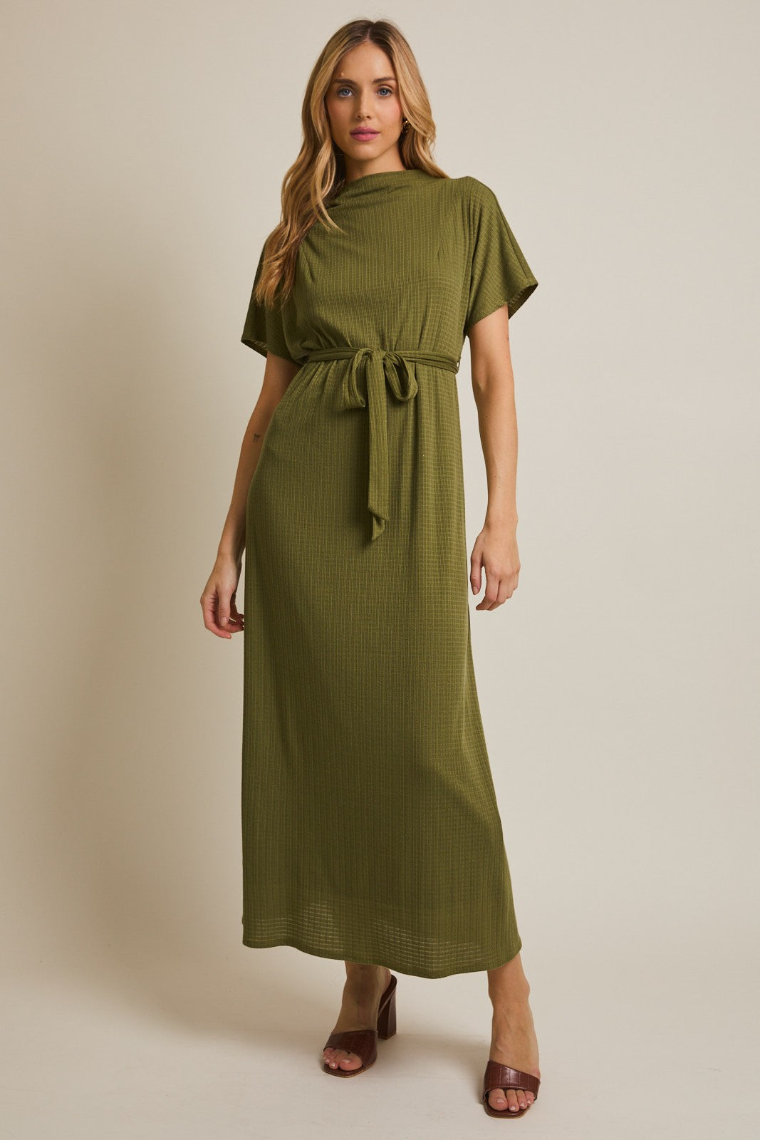 woman wearing an olive green short sleeve maxi dress with a belt and a ribbed texture