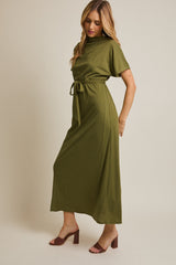 woman wearing an olive green ribbed maxi dress with a belted waist and short sleeves