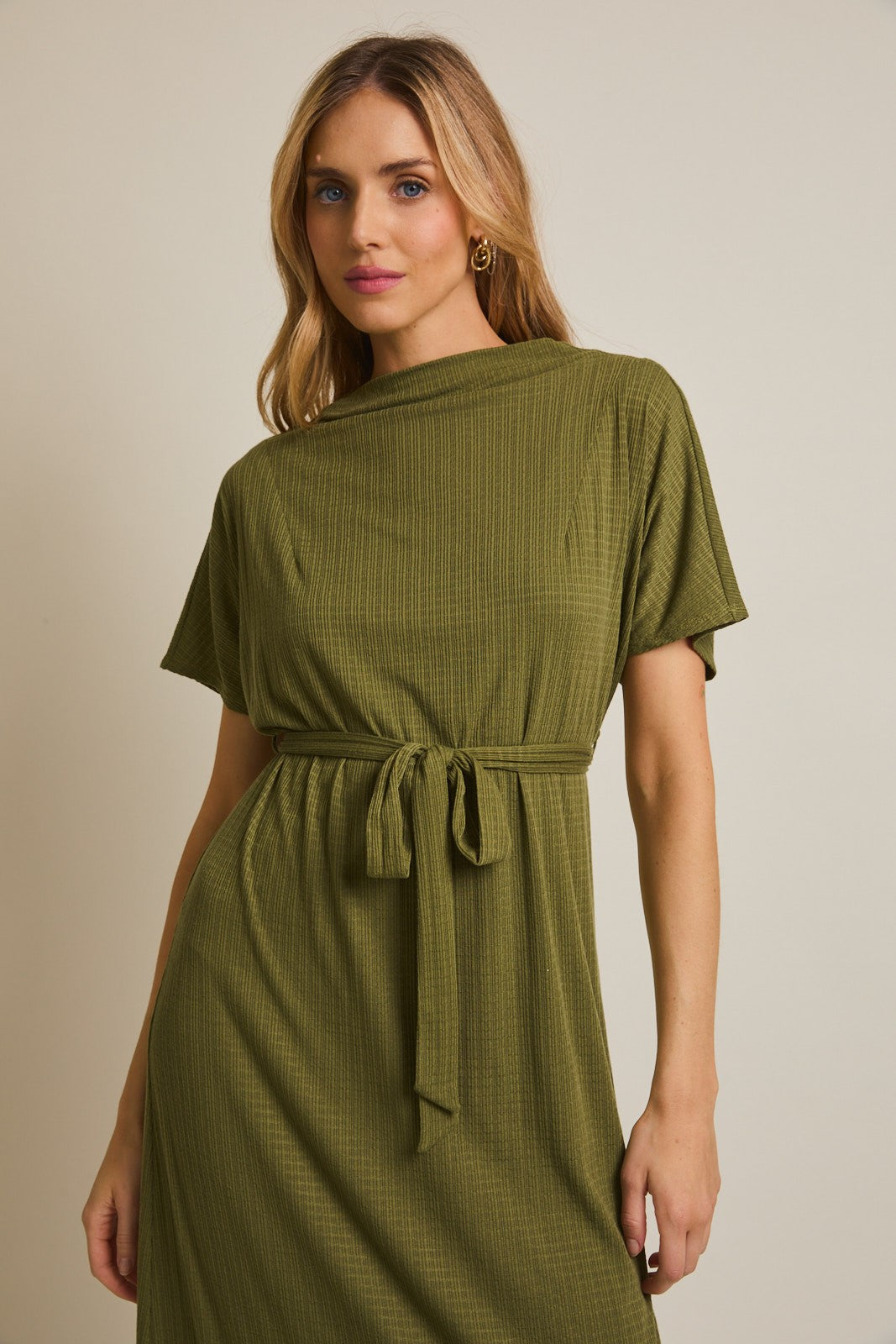 woman wearing an olive green short sleeve dress with a tie waist detail and soft texture