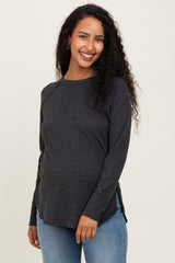 woman wearing a charcoal gray maternity long sleeve top with side slits and a visible baby bump
