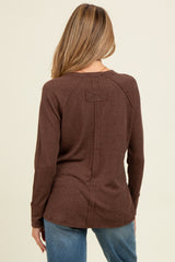 woman wearing a brown long sleeve maternity top, showing the back view with a relaxed fit and seam detailing