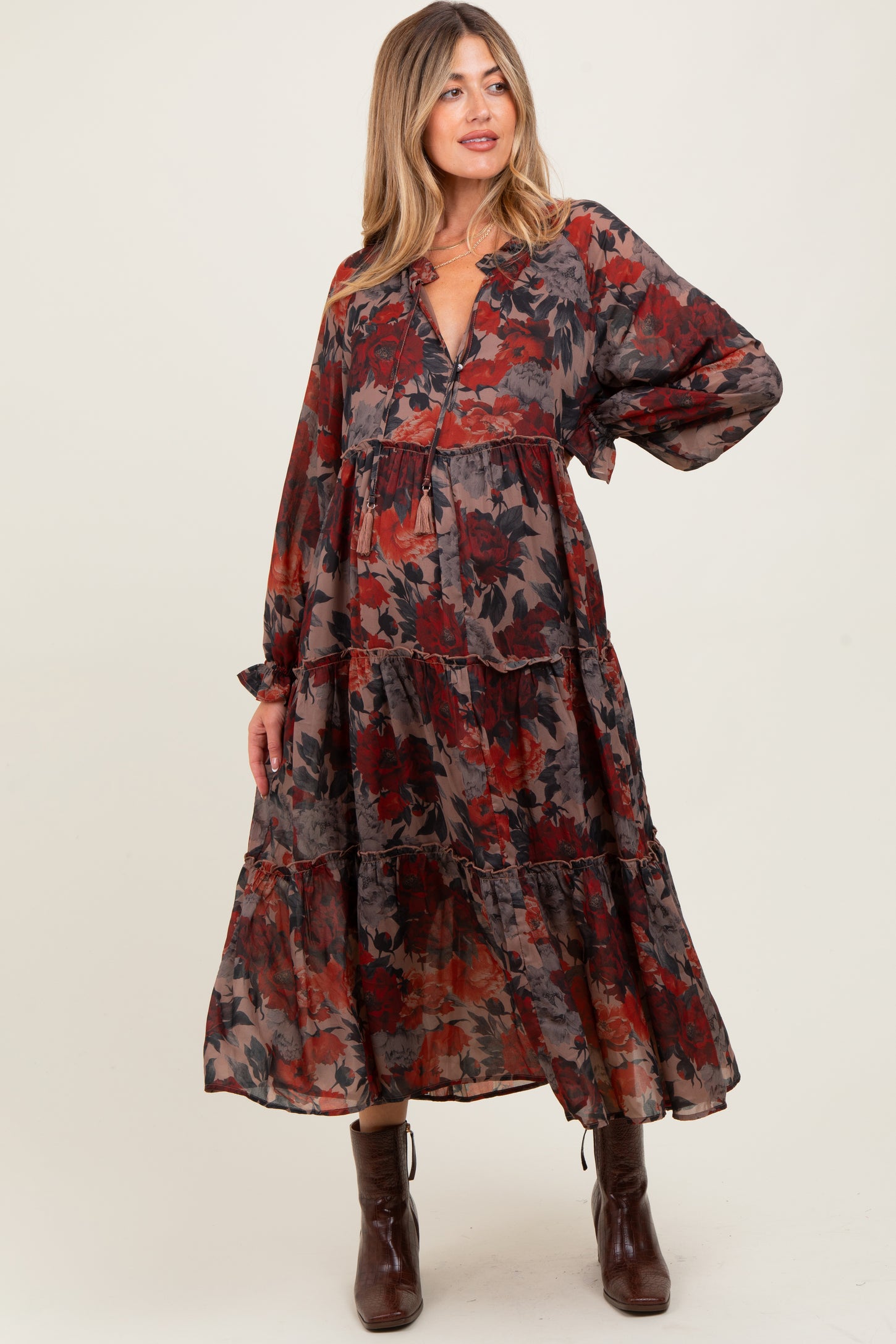 woman wearing a floral patterned maternity maxi dress with long sleeves and a tiered skirt