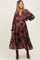 woman wearing a floral patterned maternity maxi dress with long sleeves and a tiered skirt