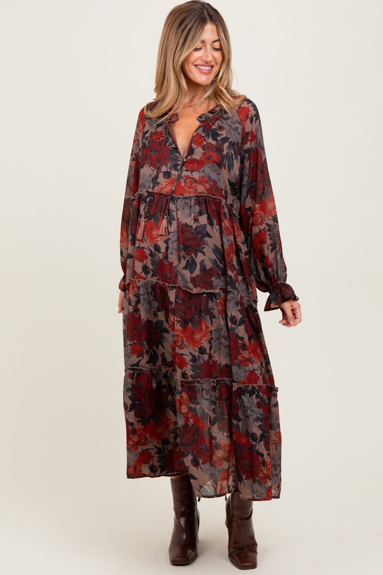 woman wearing a floral tiered maternity maxi dress with long sleeves and a v-neck, smiling, baby bump visible