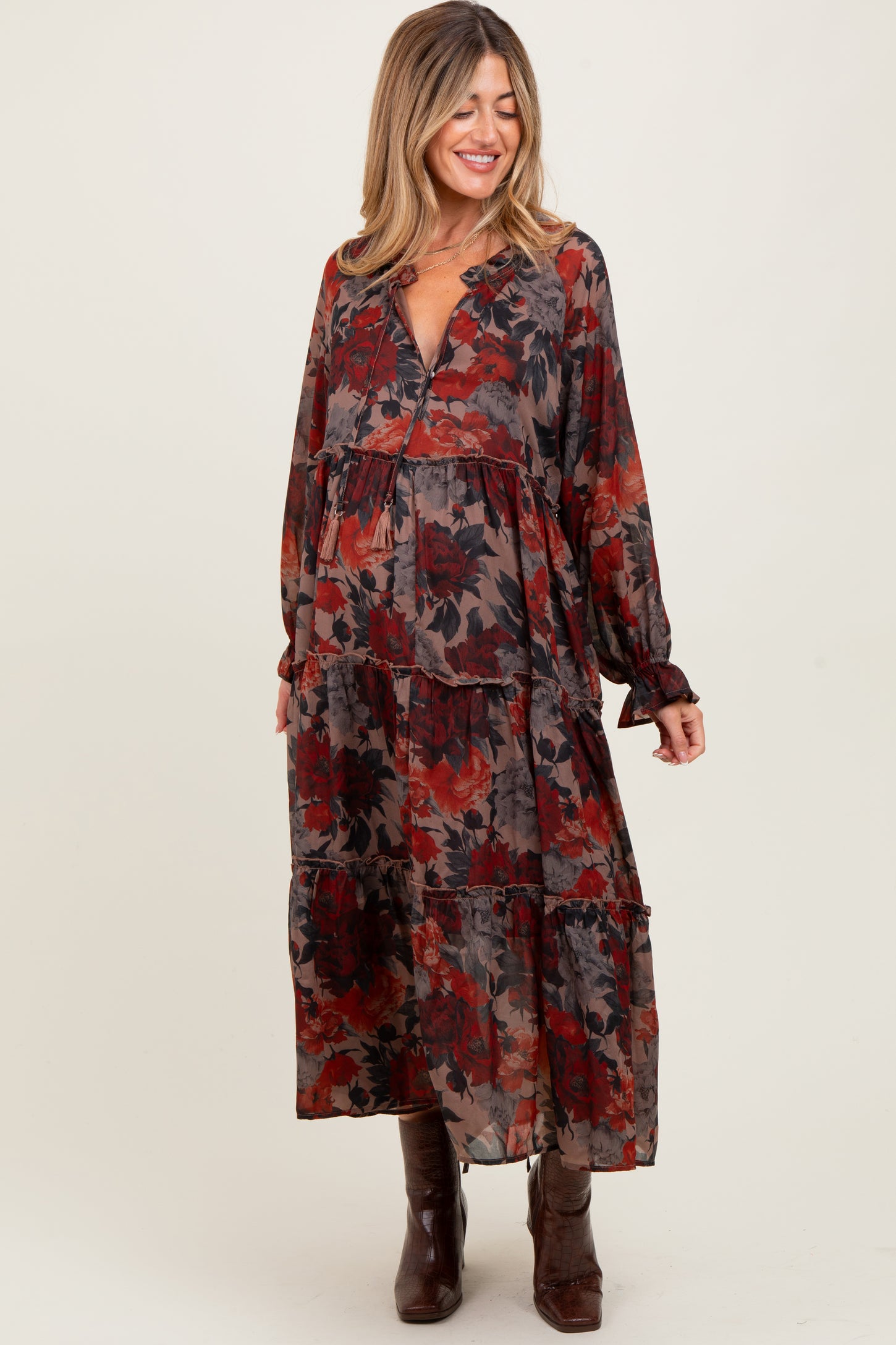 woman wearing a floral tiered maternity maxi dress with long sleeves and a v-neck, smiling, baby bump visible