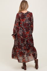 woman wearing a floral print maternity maxi dress with long sleeves and tiered ruffles, showing a baby bump