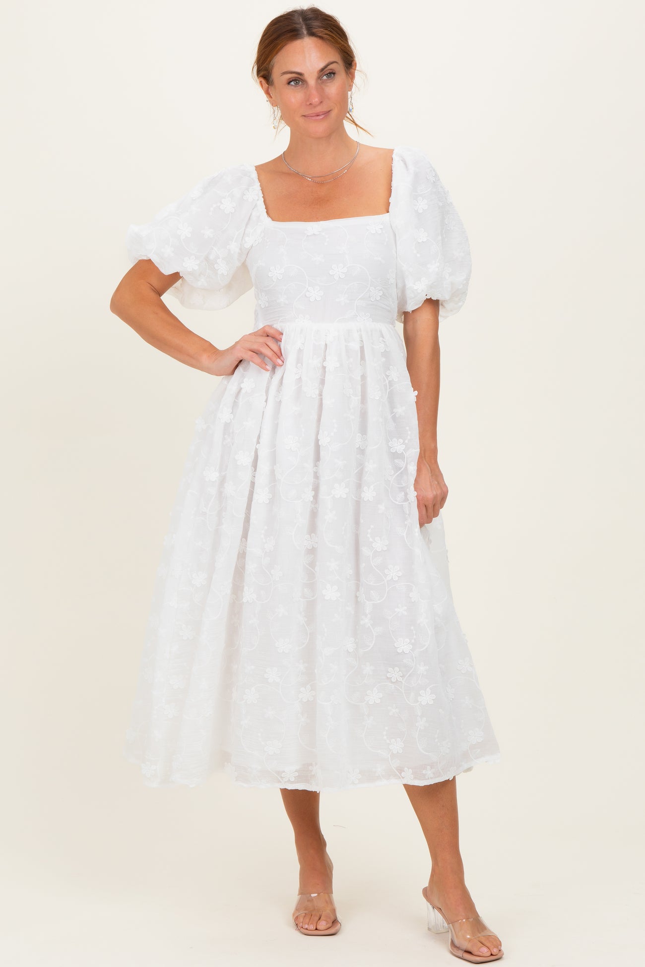 woman wearing a white floral midi dress with puff sleeves and a square neckline