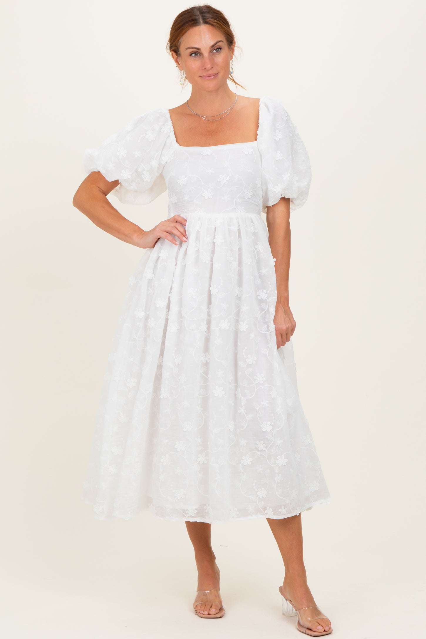 woman wearing a white floral midi dress with puff sleeves and a square neckline