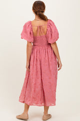 woman wearing a pink floral maxi dress with puff sleeves and a smocked back detail