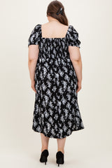 woman wearing a black floral maternity plus dress with puff sleeves and a square neckline, showing the back view