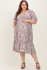 woman wearing a lavender floral maternity dress with short puff sleeves and a tiered skirt, showing a baby bump