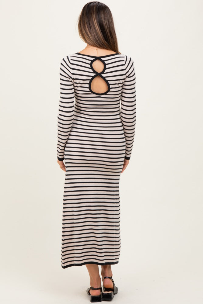 woman wearing a black and ivory striped long sleeve maternity dress with open back detail