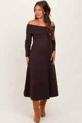 woman wearing a chocolate brown off-shoulder maternity dress with long sleeves and a visible baby bump