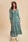 woman wearing a teal long sleeve maxi dress with a square neckline and ruffled tiers, styled with a white cowboy hat and boots