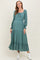 woman wearing a dusty teal maternity dress with long sleeves and tiered ruffle details, featuring a tied neckline