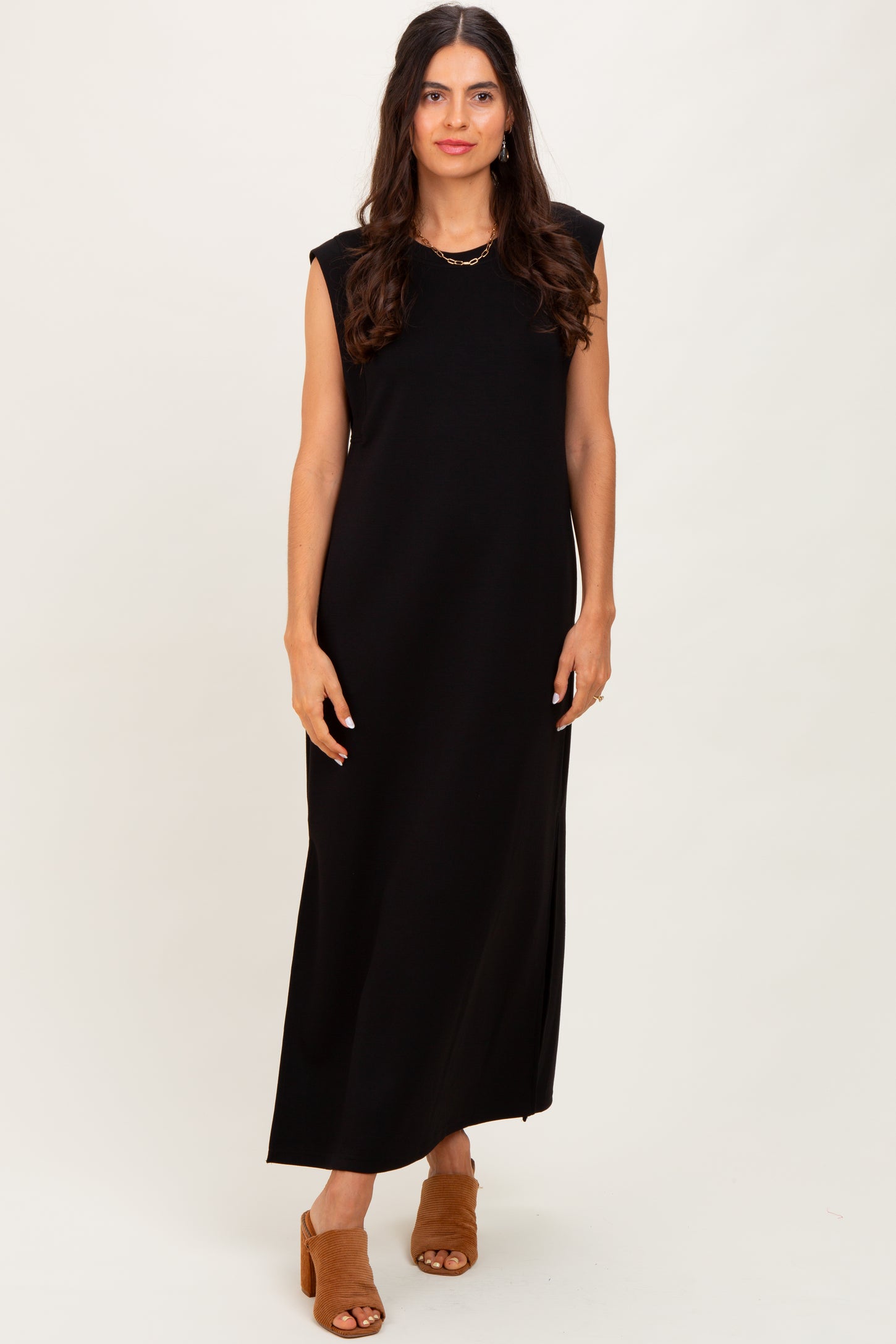 woman wearing a black sleeveless maxi dress with side slits and a relaxed fit