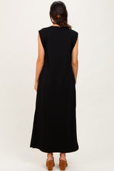 woman wearing a black sleeveless maxi dress with side slits, viewed from the back