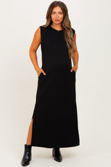 woman wearing a black sleeveless maternity maxi dress with side pockets and a thigh-high slit