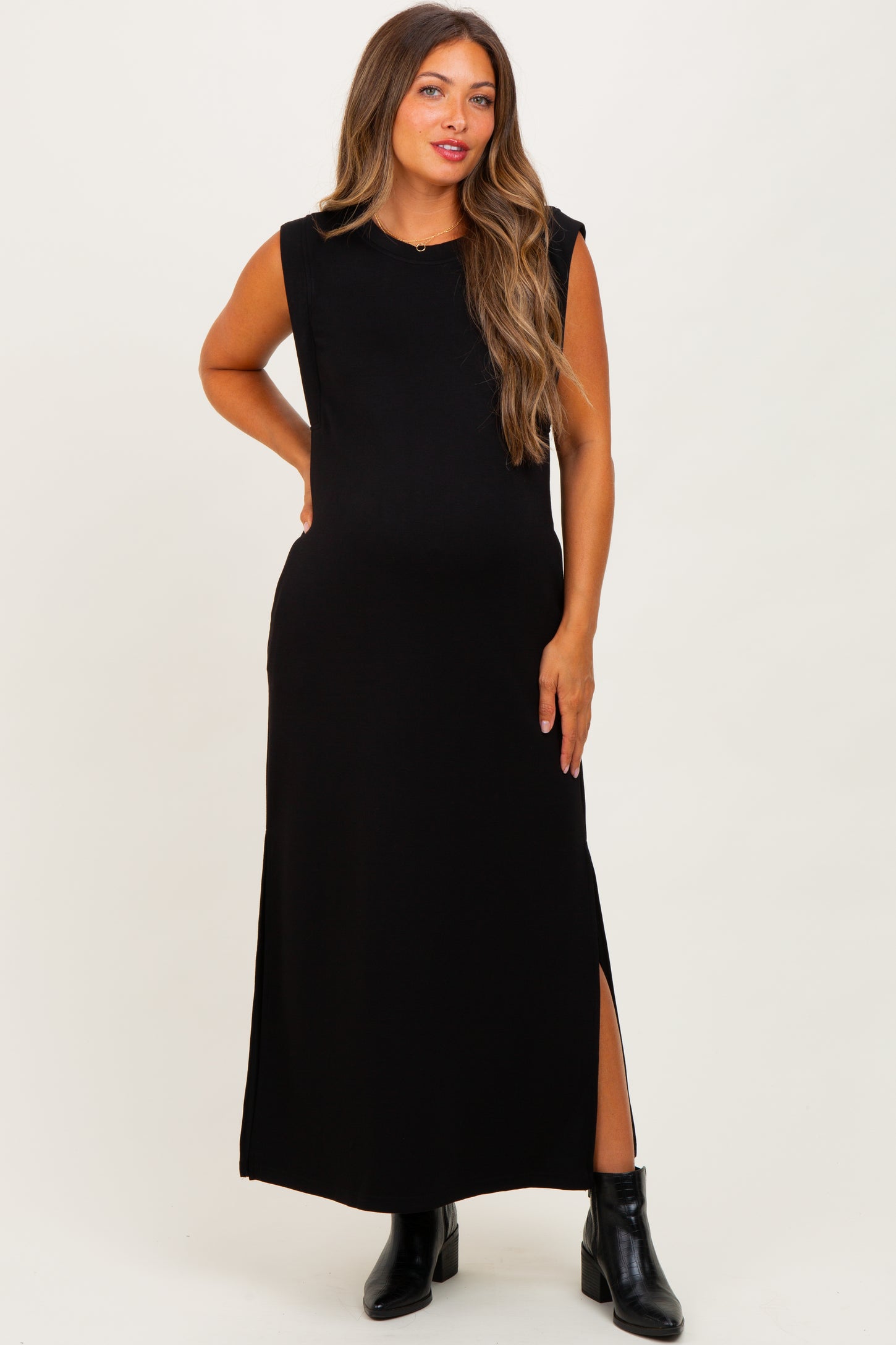 woman wearing a black sleeveless maxi maternity dress with a side slit and a visible baby bump